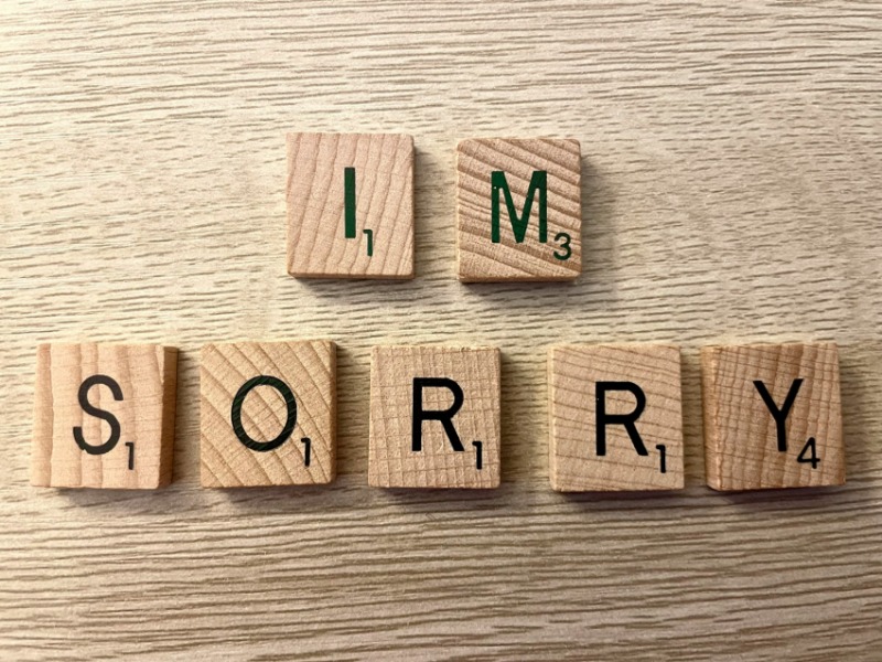 'IM SORRY' spelled in Scrabble tiles on wooden table