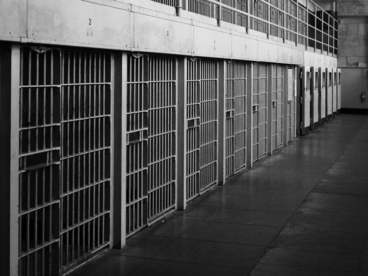 Prison cells in concrete hallway