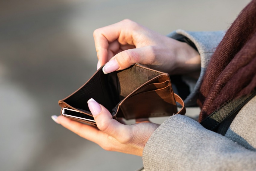 Woman opening empty leather wallet