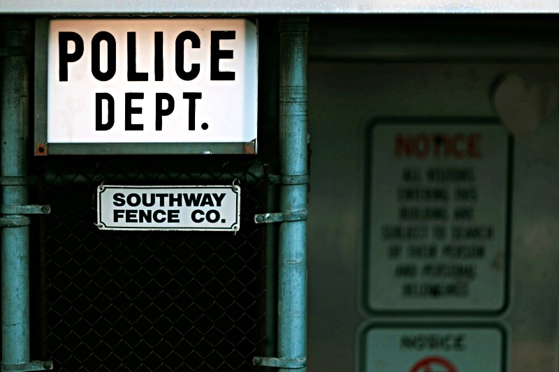 Police department entrance with warning signs