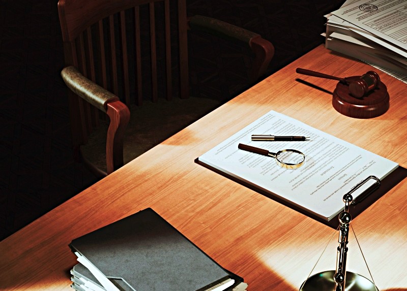 lLegal forms on politician's desk with gavel, magnifying glass and law books