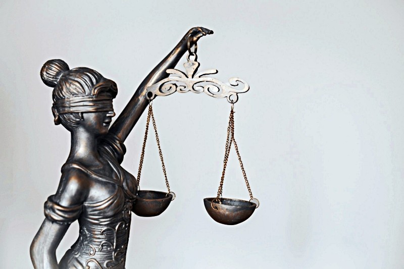 Blindfolded Lady Justice statue with metal scales