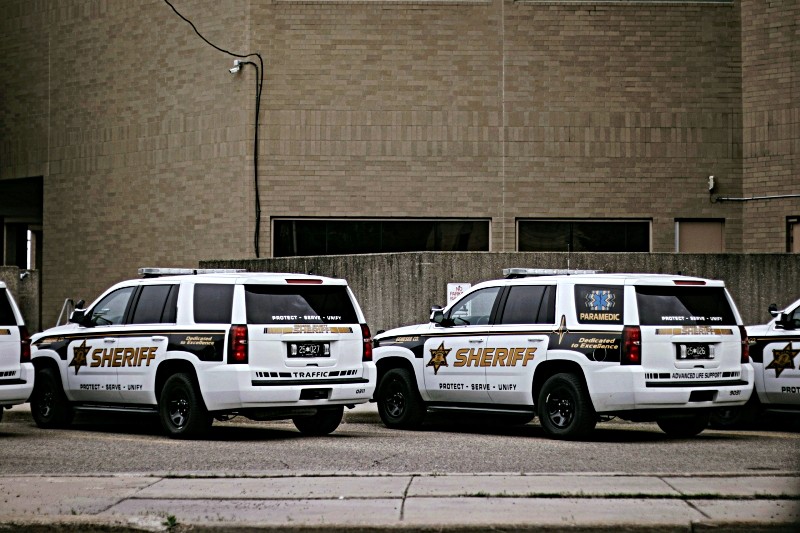 Two police SUVs outside detention center building