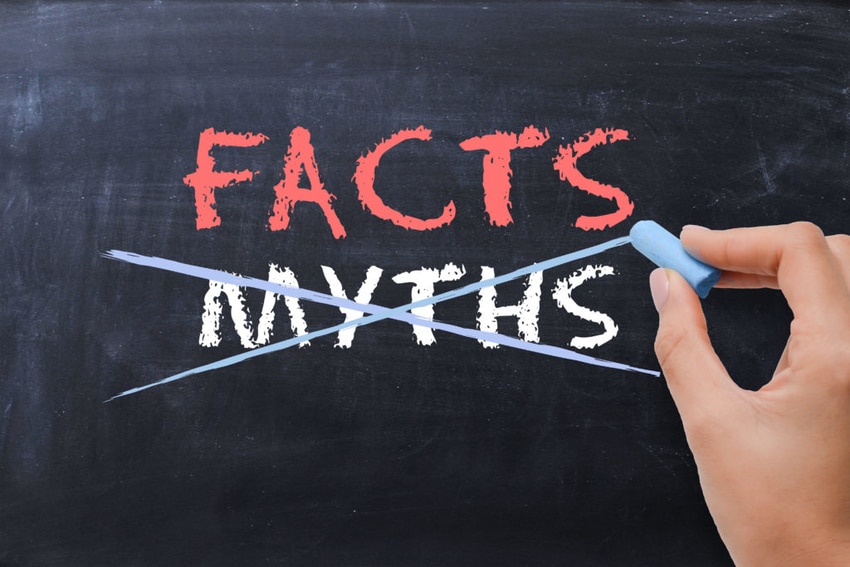 Hand crossing out 'MYTHS' on chalkboard with 'FACTS' written just above