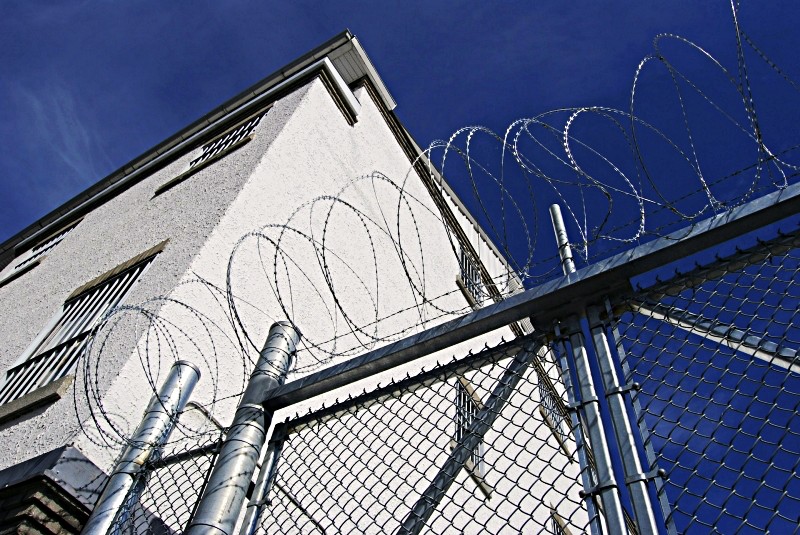 Chain link fence with barbed wire and gate to exit detention center yard