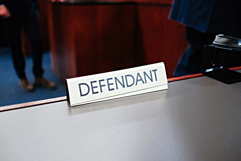 'Defendant' placard on courtroom table